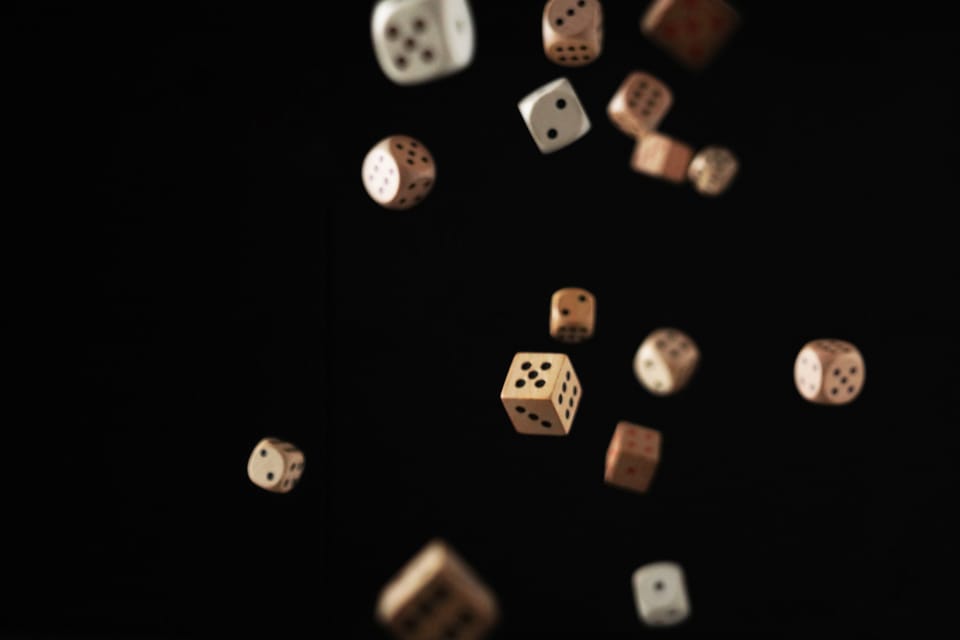 Image: wooden dice falling on a black background