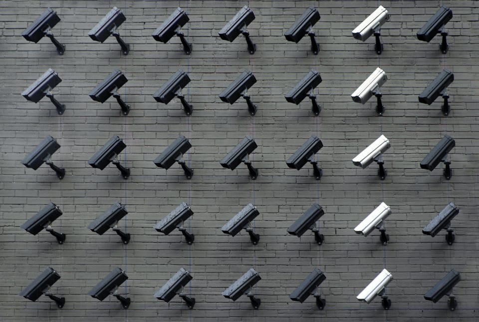 Image: Rows of security cameras on a brick wall
